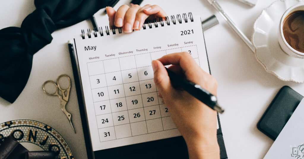 Calendar being held by a woman holding a pen indicating the closing timeline